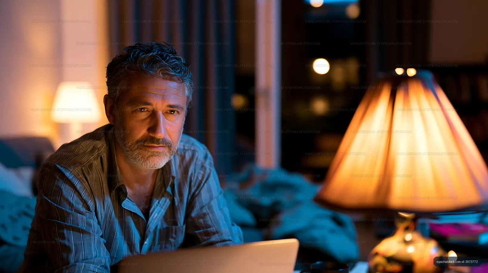 Man works late at night on a laptop in a cozy room