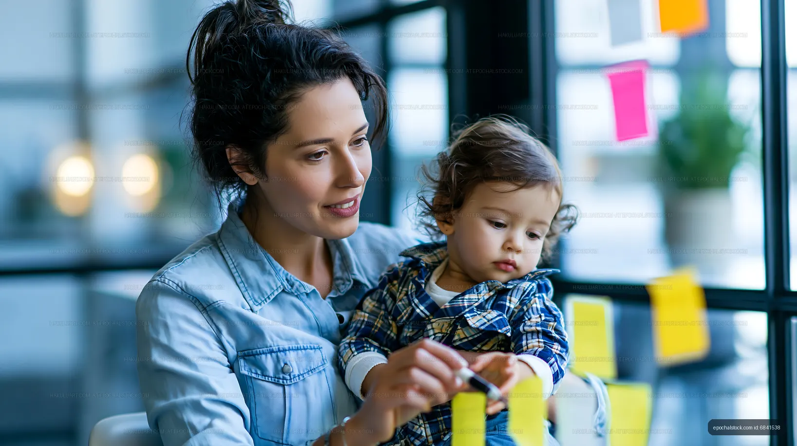 Mom helps child with sticky notes in a bright workspace
