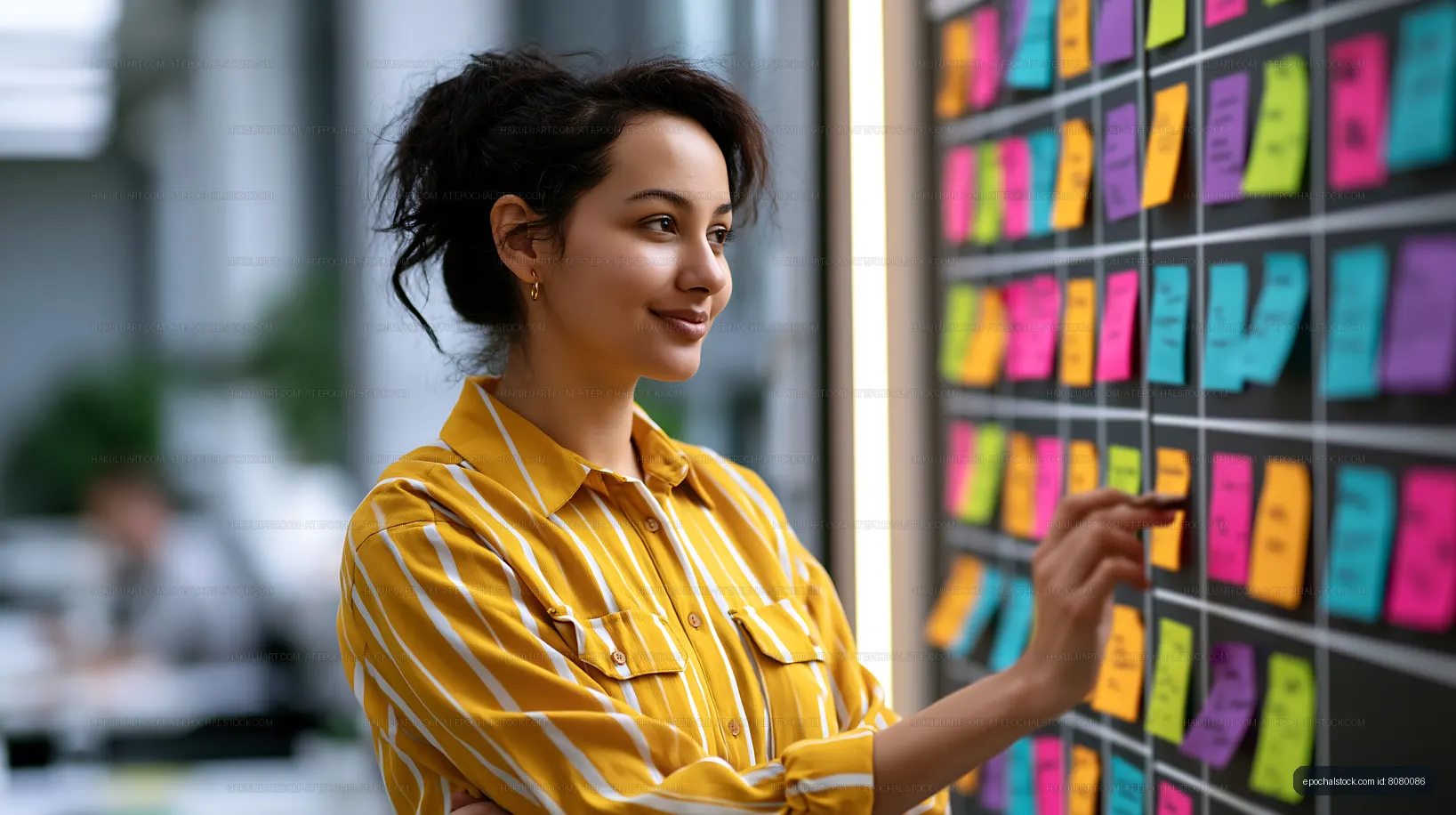 Woman working with sticky notes on a board in an office