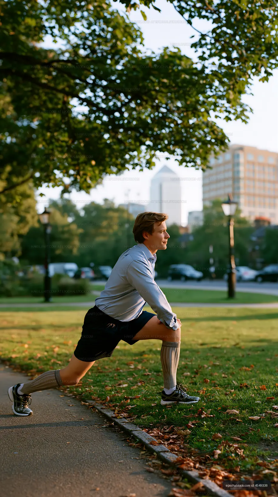 Man stretching in a park with city buildings in the background