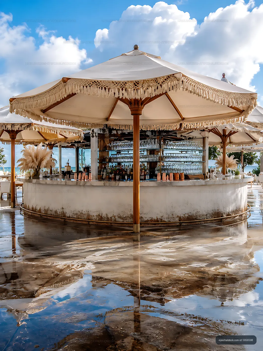 Bar with umbrellas at a beachside location reflecting in water