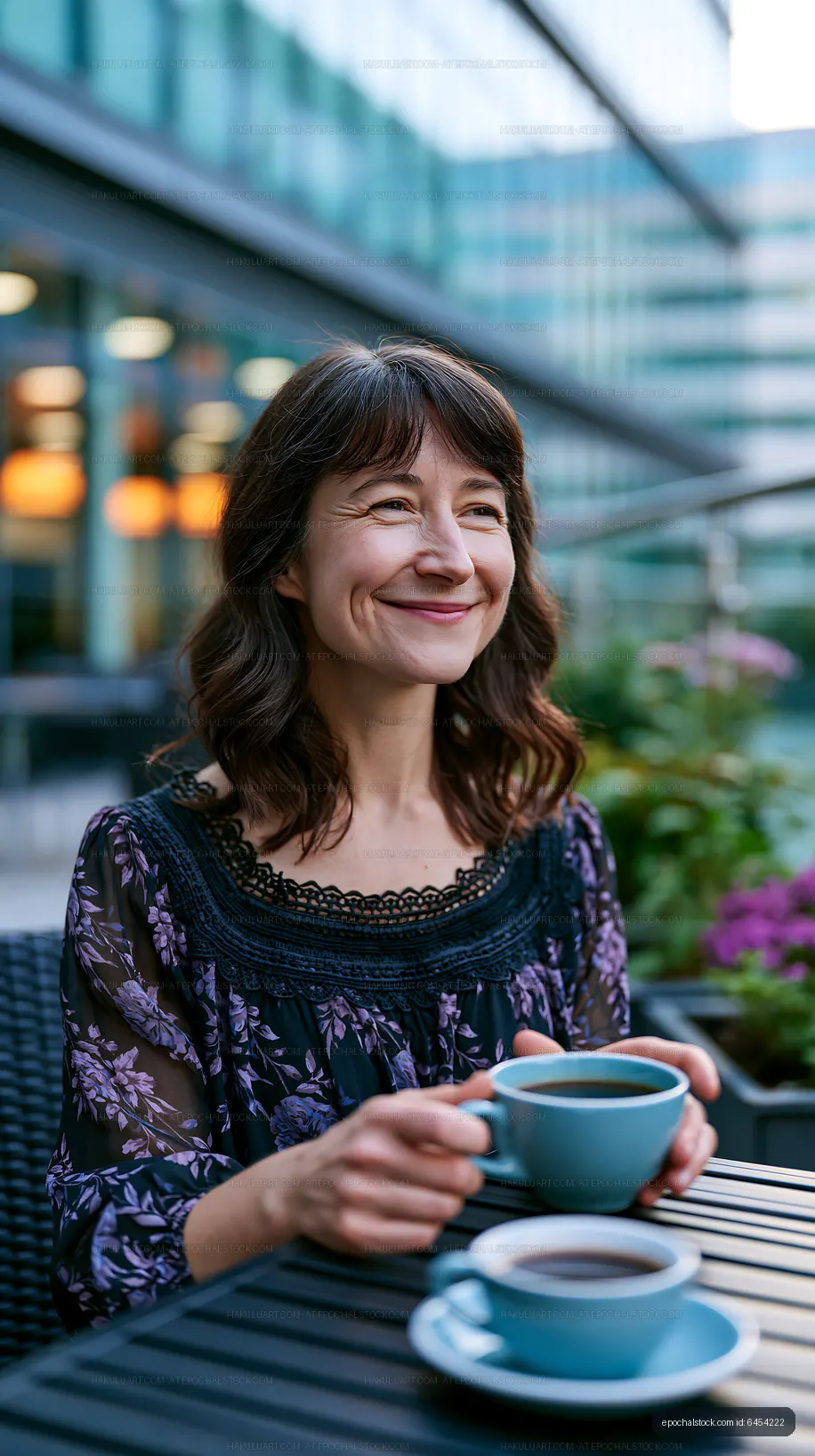 Woman smiling while enjoying coffee at outdoor cafe