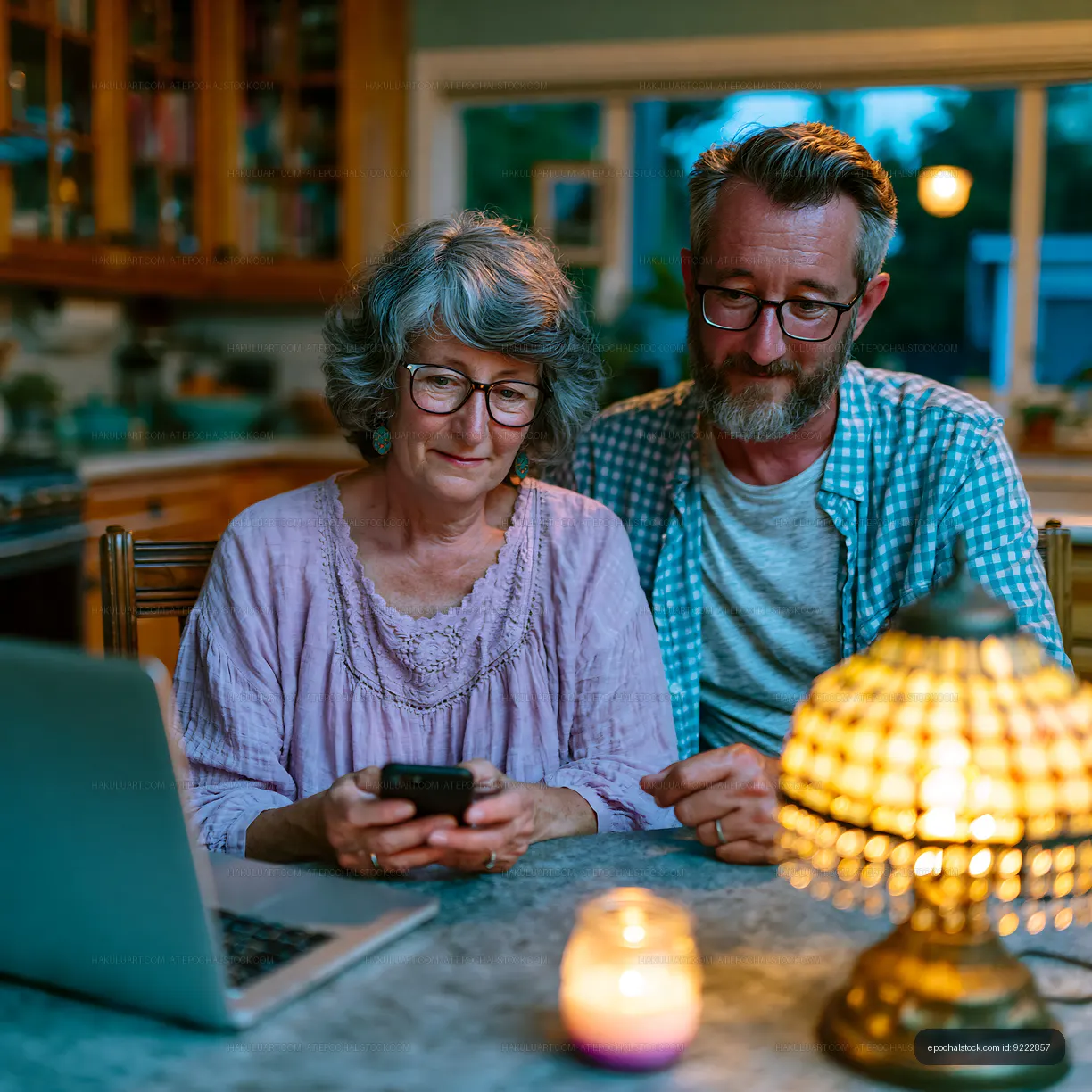 Couple using smartphone and laptop at home in the evening