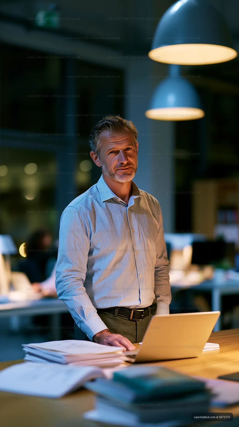 Businessman working late at desk in modern office setting