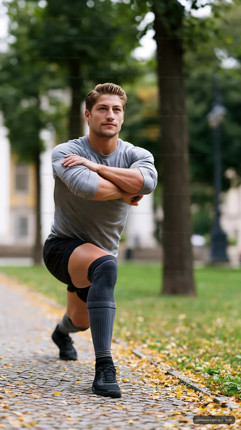 Man performs a lunge exercise in a city park during daytime
