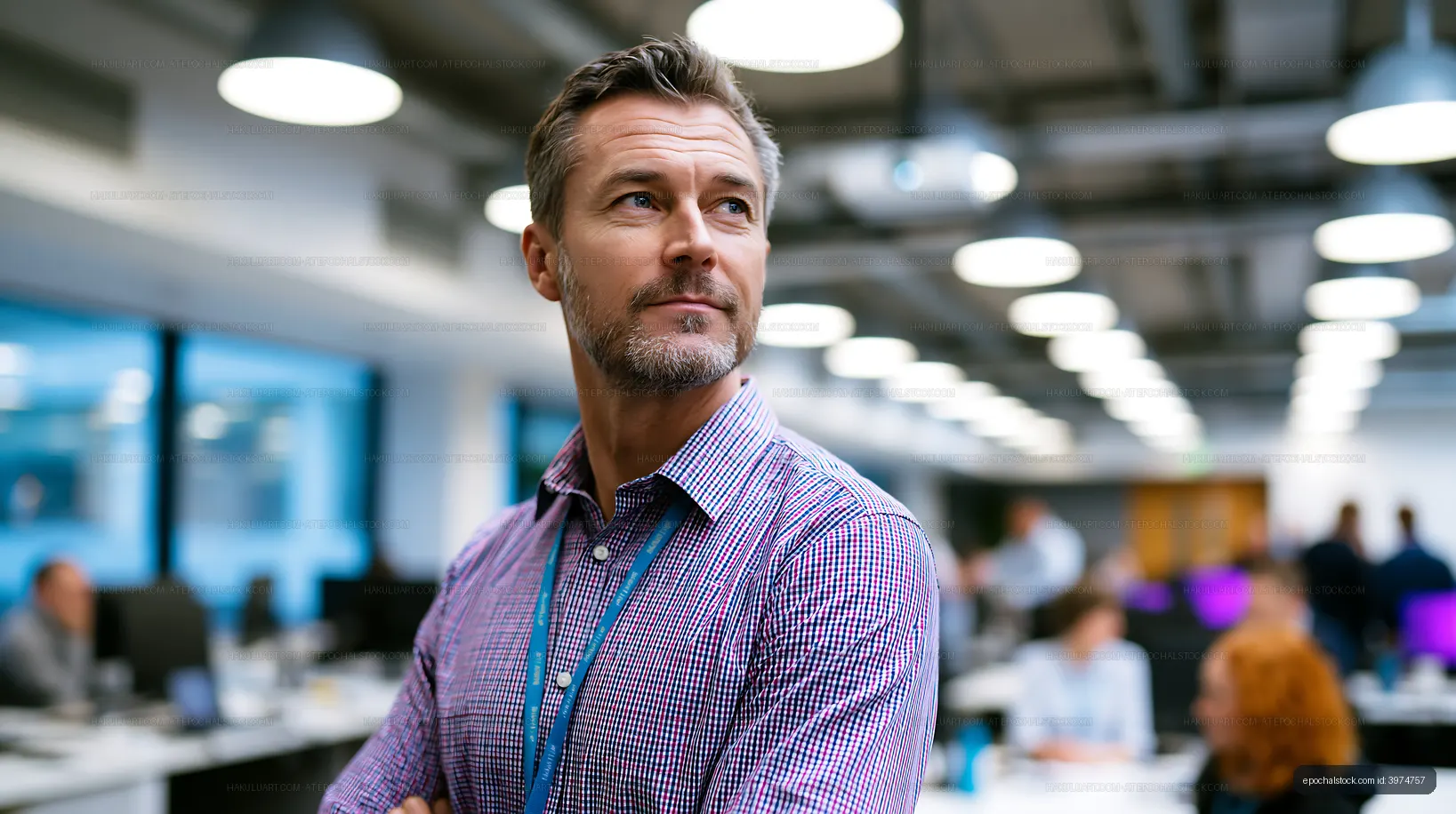 Businessman standing in modern office with colleagues working