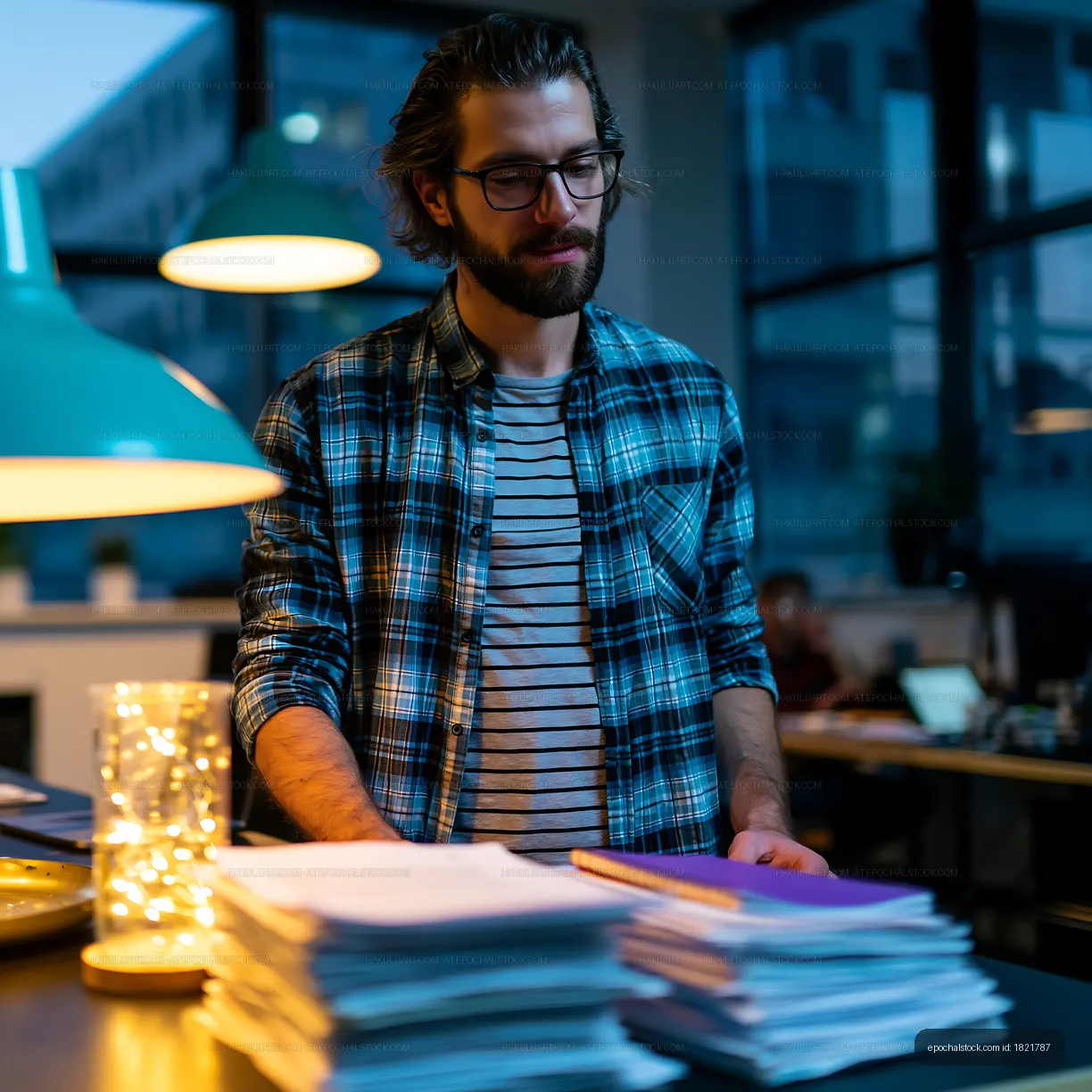 Young man reviewing documents in a modern office at night