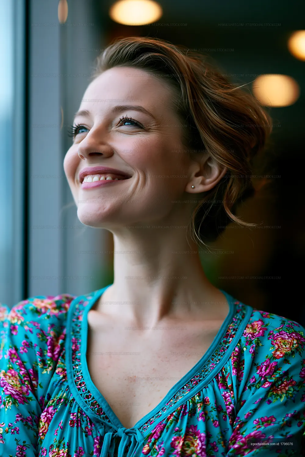 Woman smiling while looking out a window with warm lighting