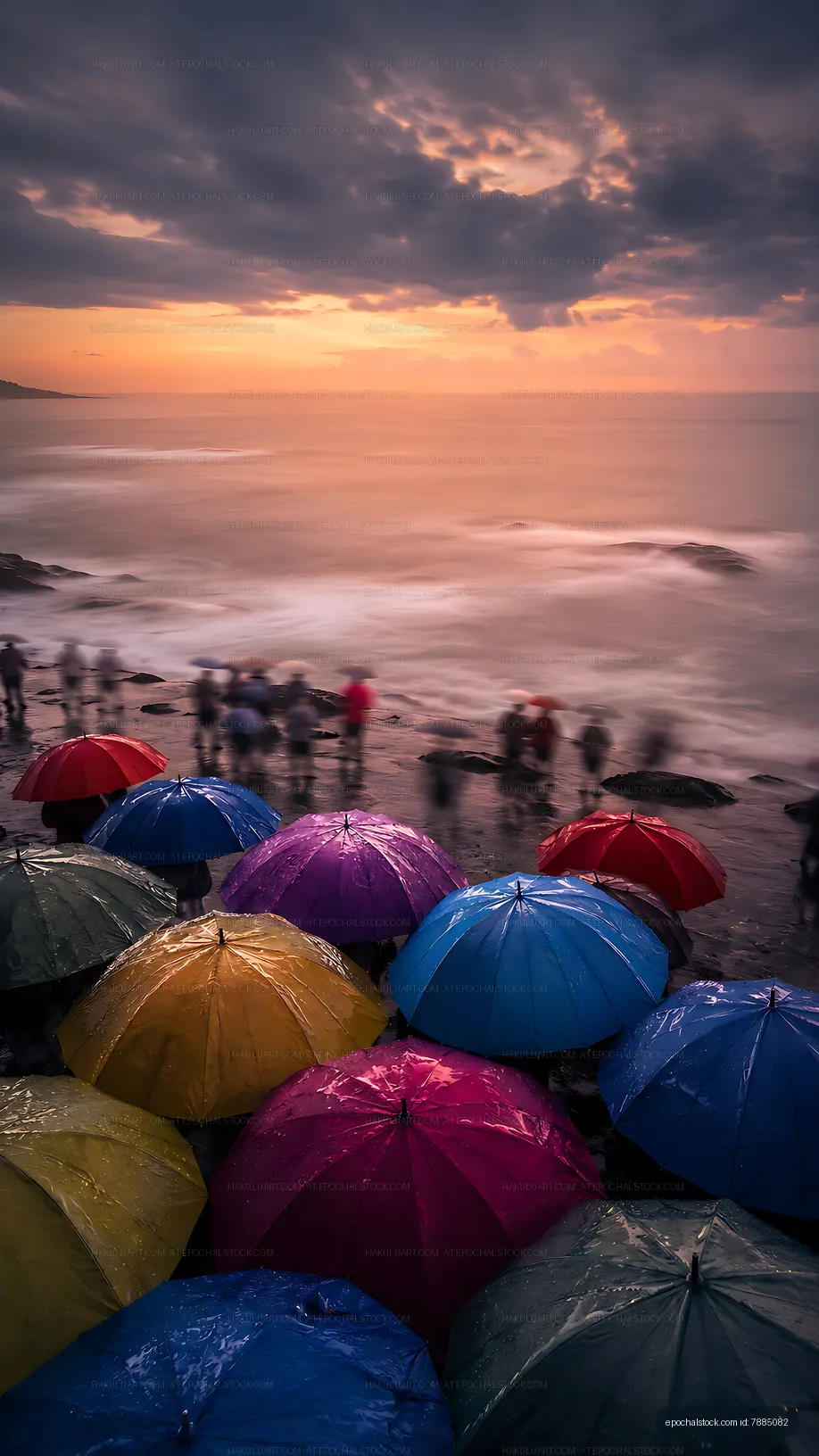 Colorful umbrellas line the shore during a coastal gathering at sunset