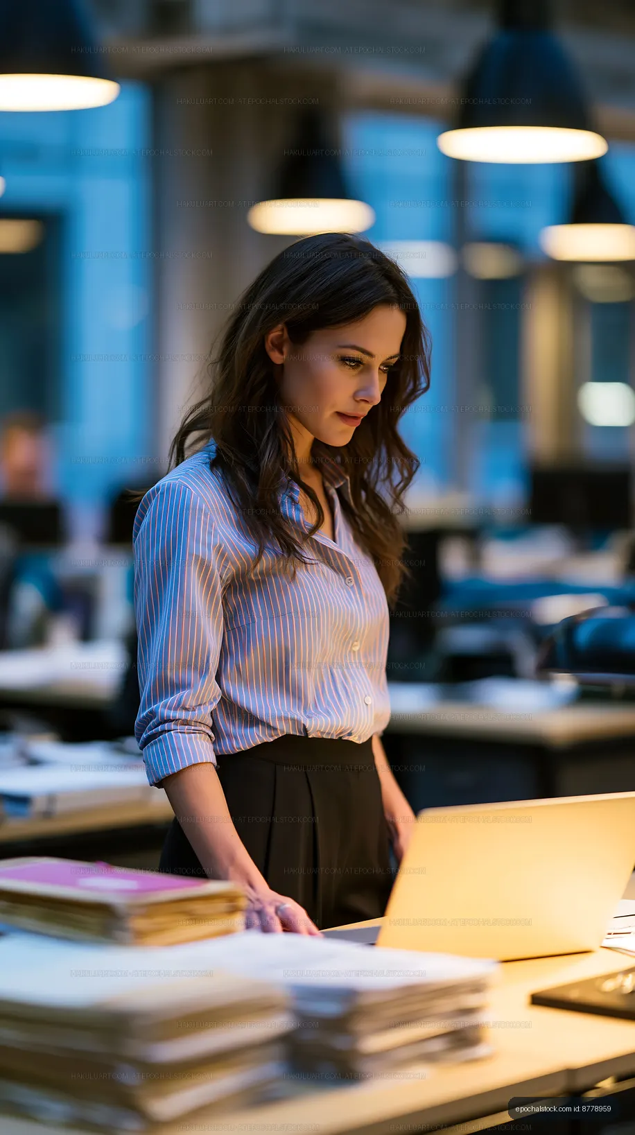 Woman working on laptop in modern office at night