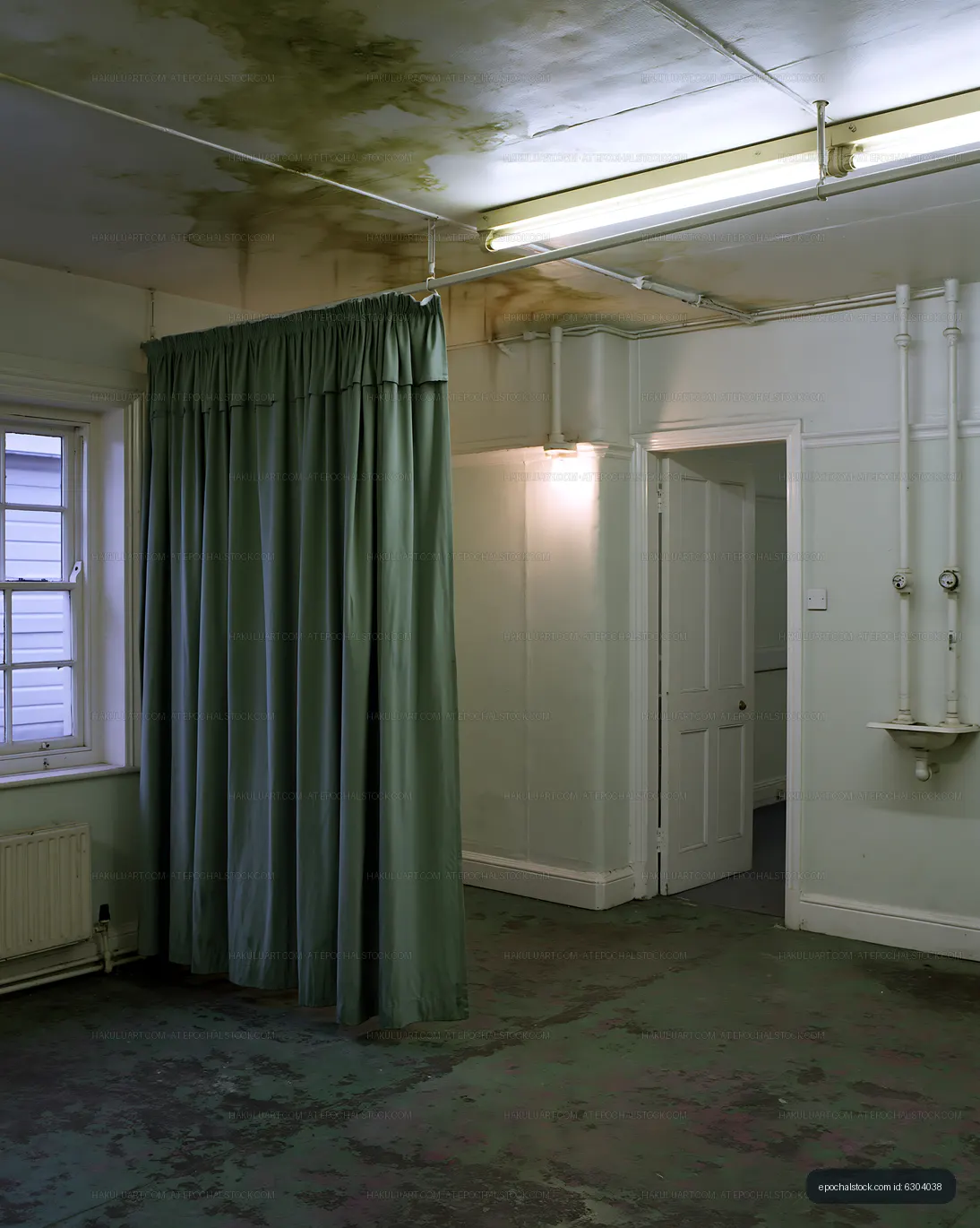 Empty room with worn curtains and water stains on the ceiling
