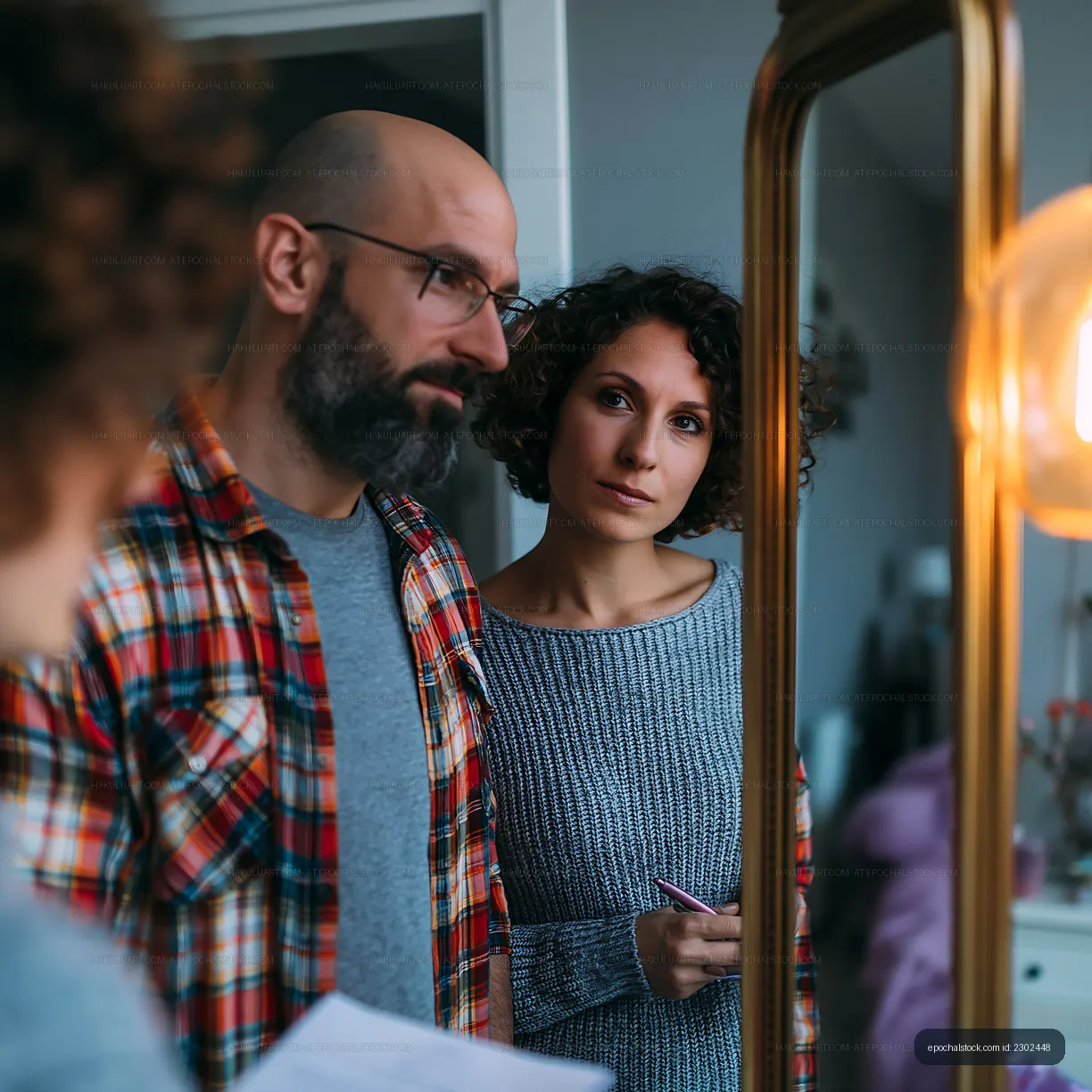 Couple looking at their reflection in a mirror at home