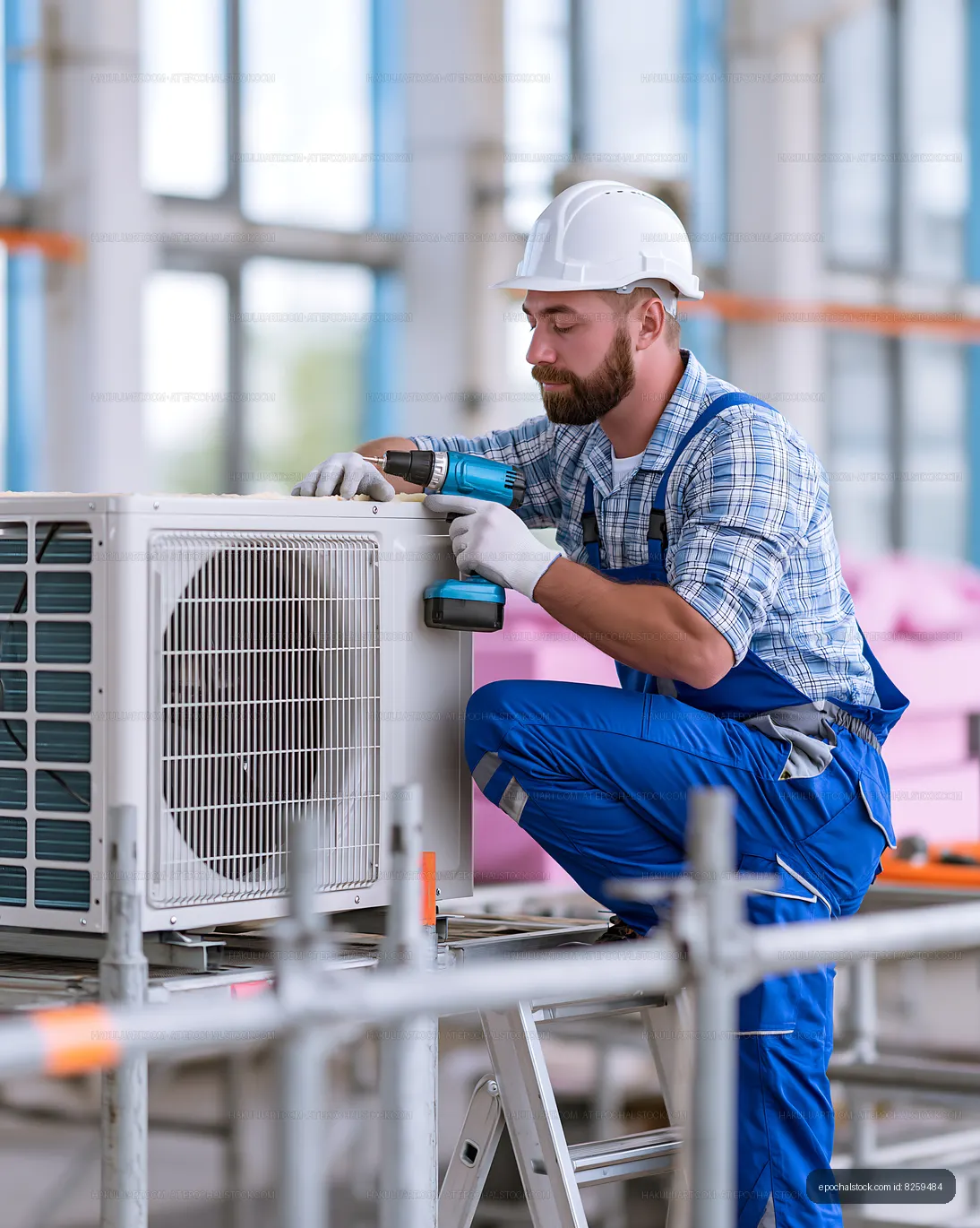 Worker installing air conditioning unit in a building site