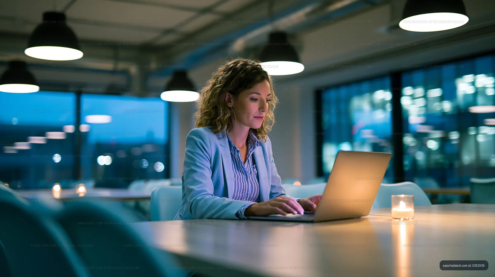 Woman working on laptop in modern office at night