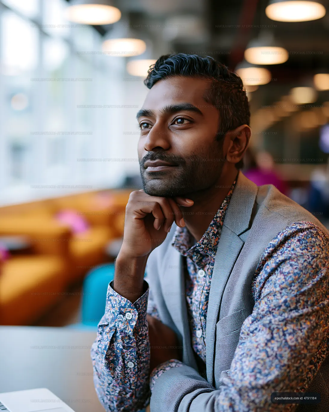 Man thinking while sitting in modern cafe