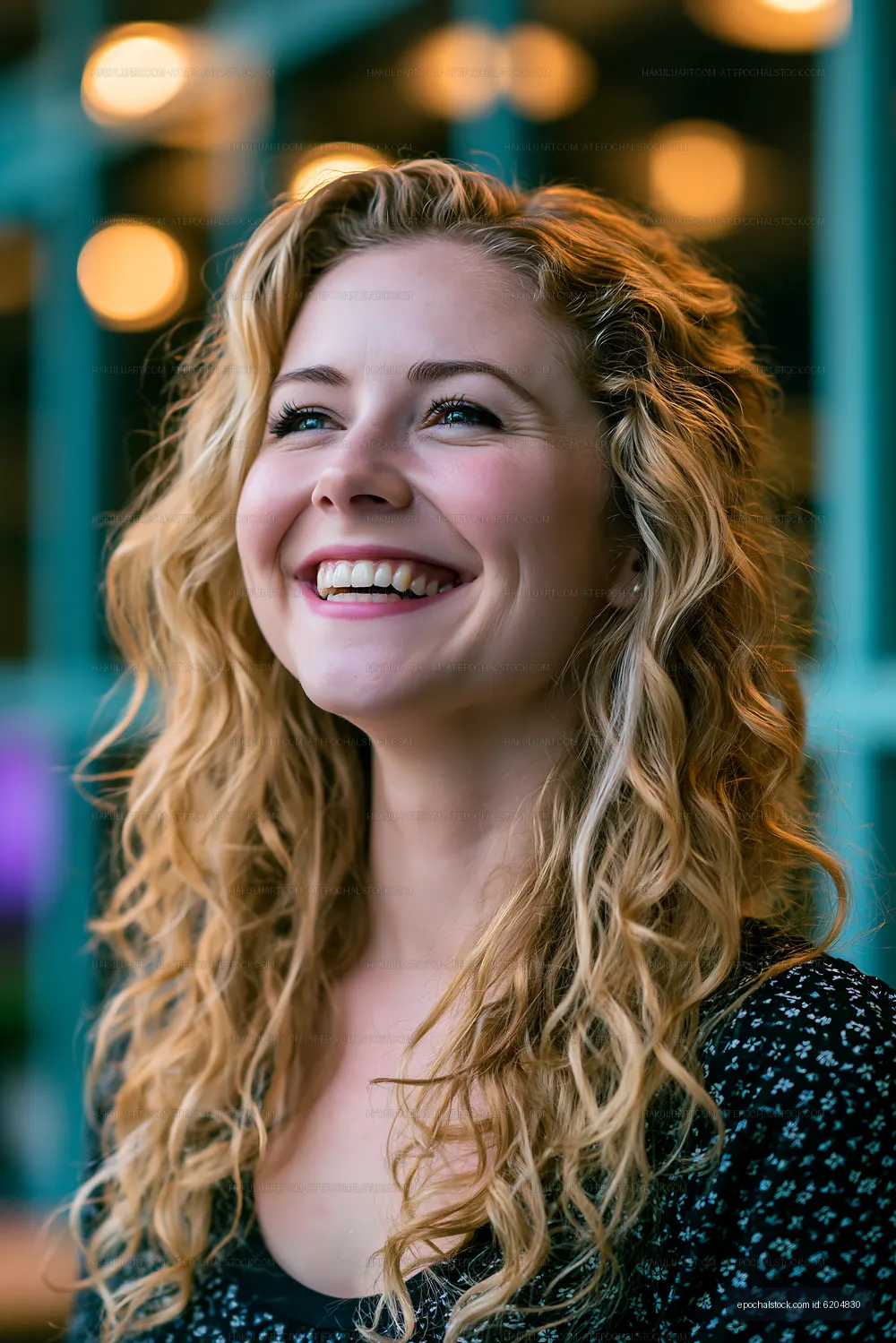 Smiling woman with curly hair in bright cafe setting