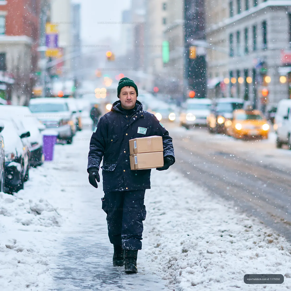 Delivery worker walks on snowy street in winter city