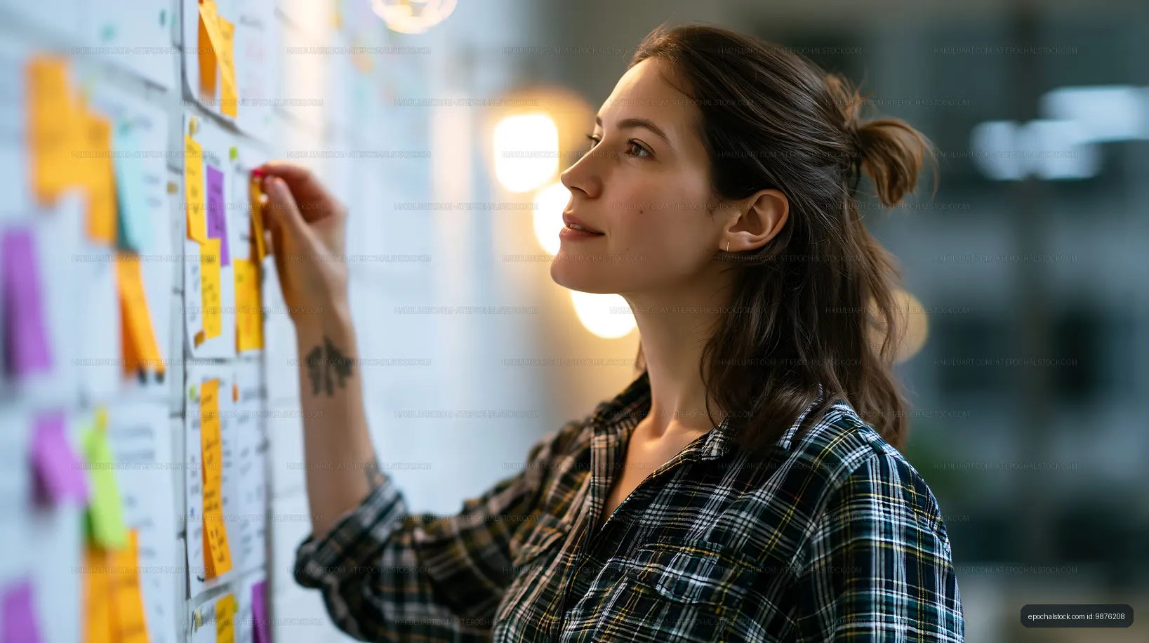 Woman working on a project with sticky notes on a wall