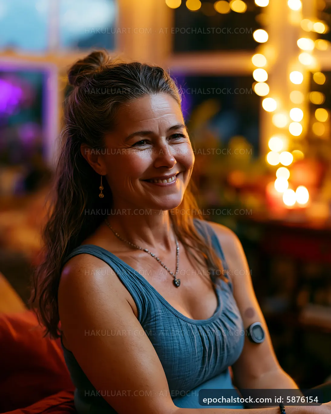 Woman sitting indoors with soft lights in the background