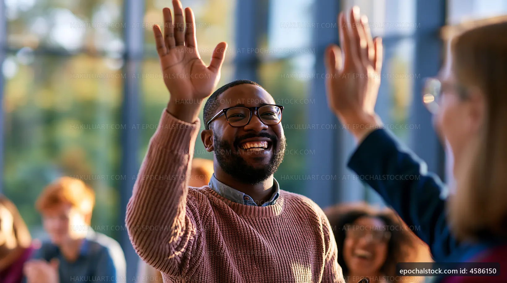 Man waving hand during group discussion in bright meeting space
