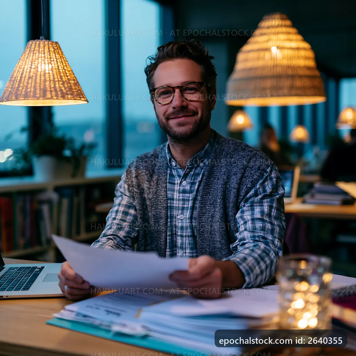 Man working with papers in a cozy office at dusk