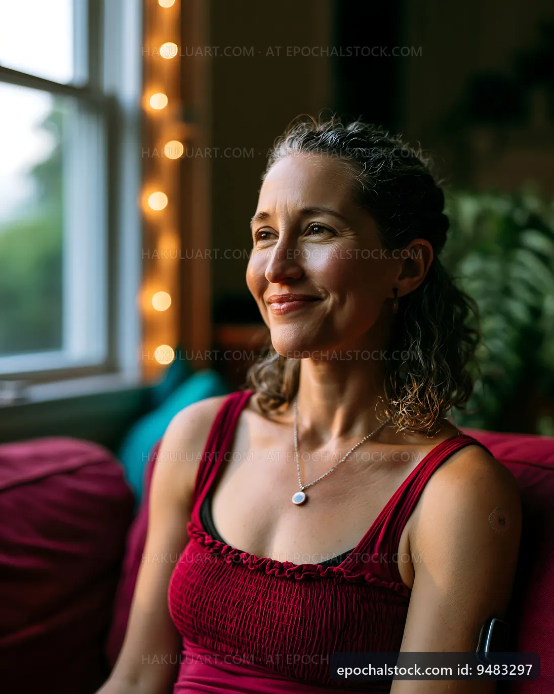 Woman sitting by a window with lights in the background