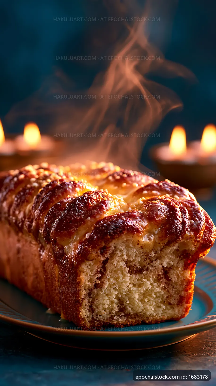 Fresh baked loaf with steam on a plate near glowing candles