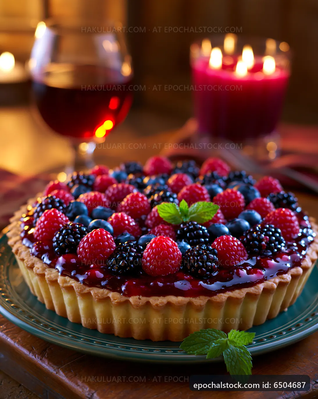 Fruit tart on a table with wine glass and candles