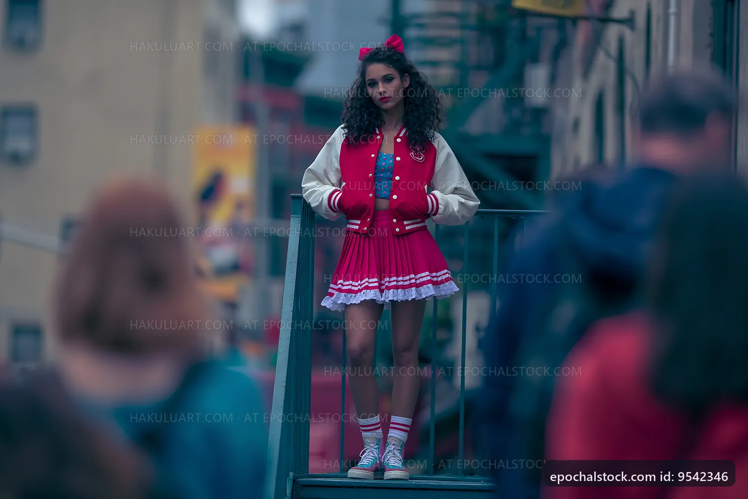 Young woman in a red dress and jacket stands on a city staircase