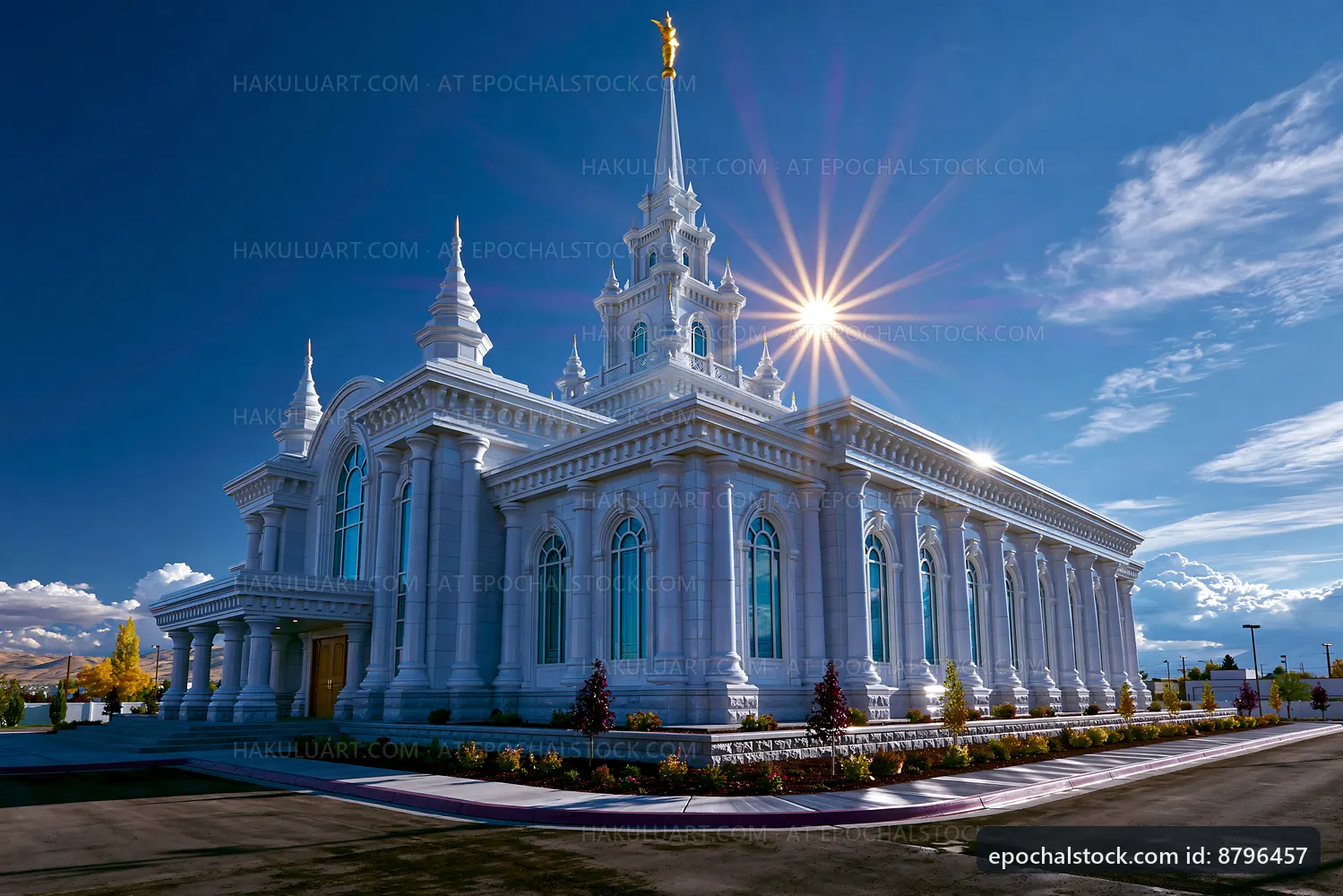Sun shining on a large white building with a tall spire