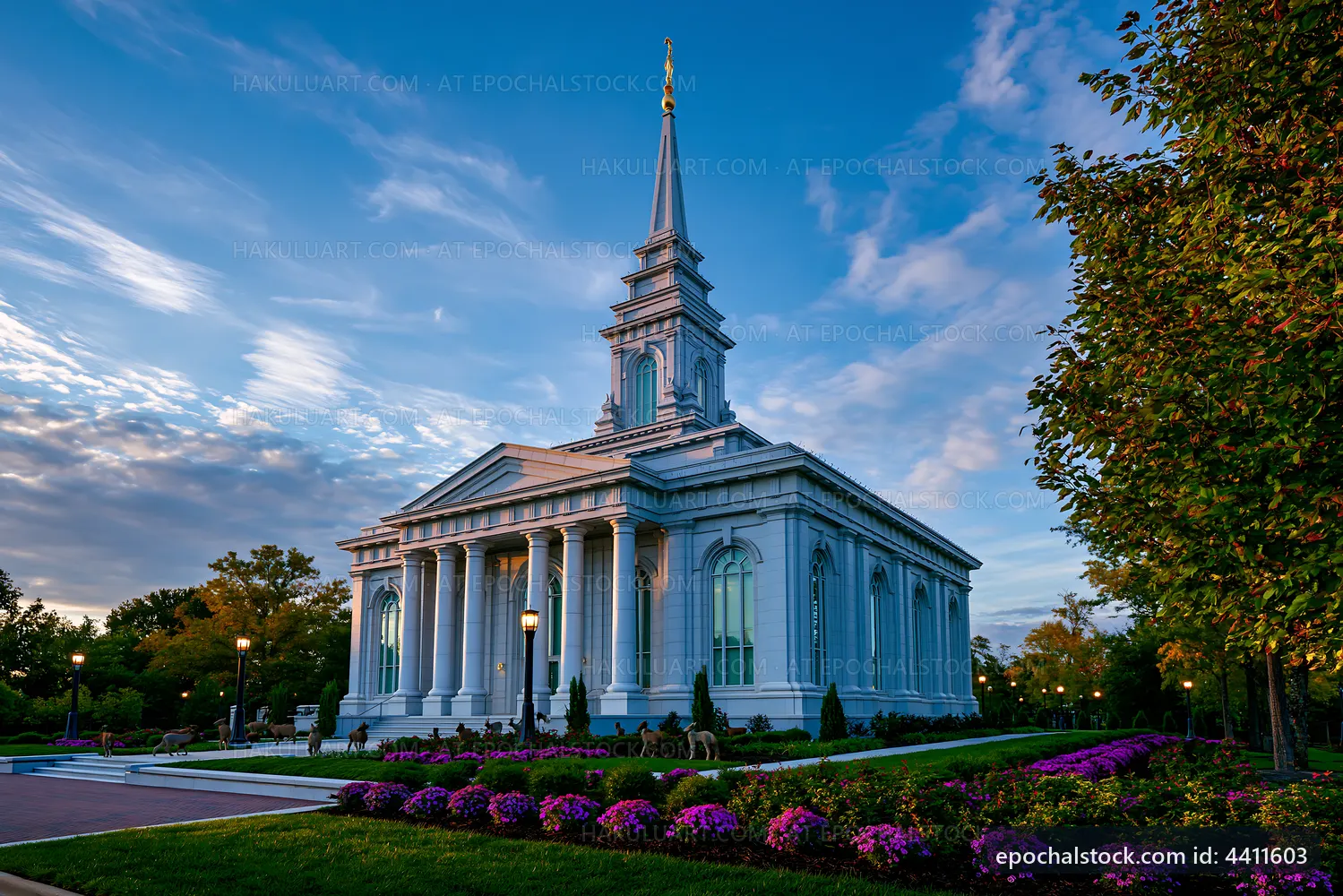 Church building under blue sky with trees and flowers