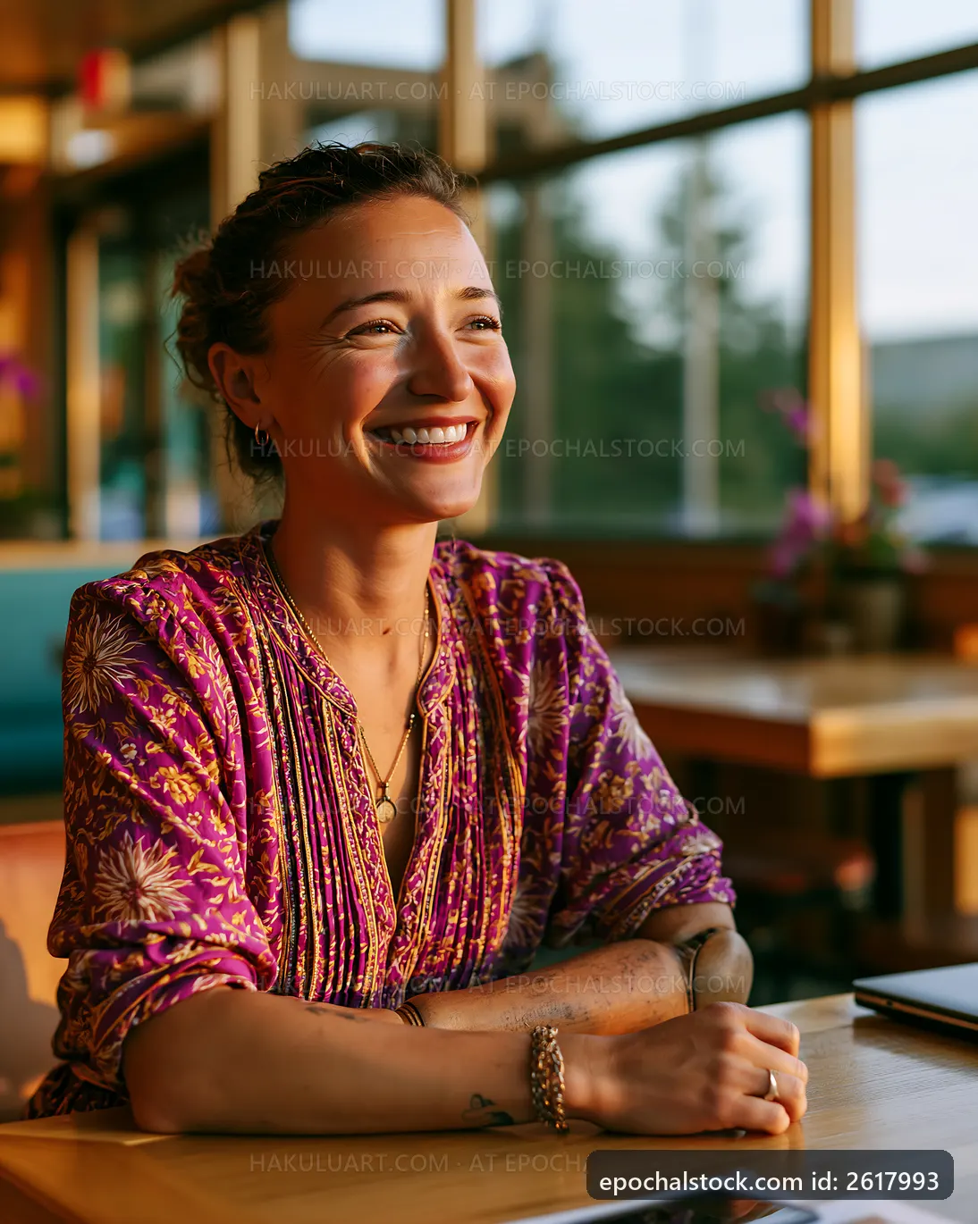 Woman smiling at a table in a bright cafe setting
