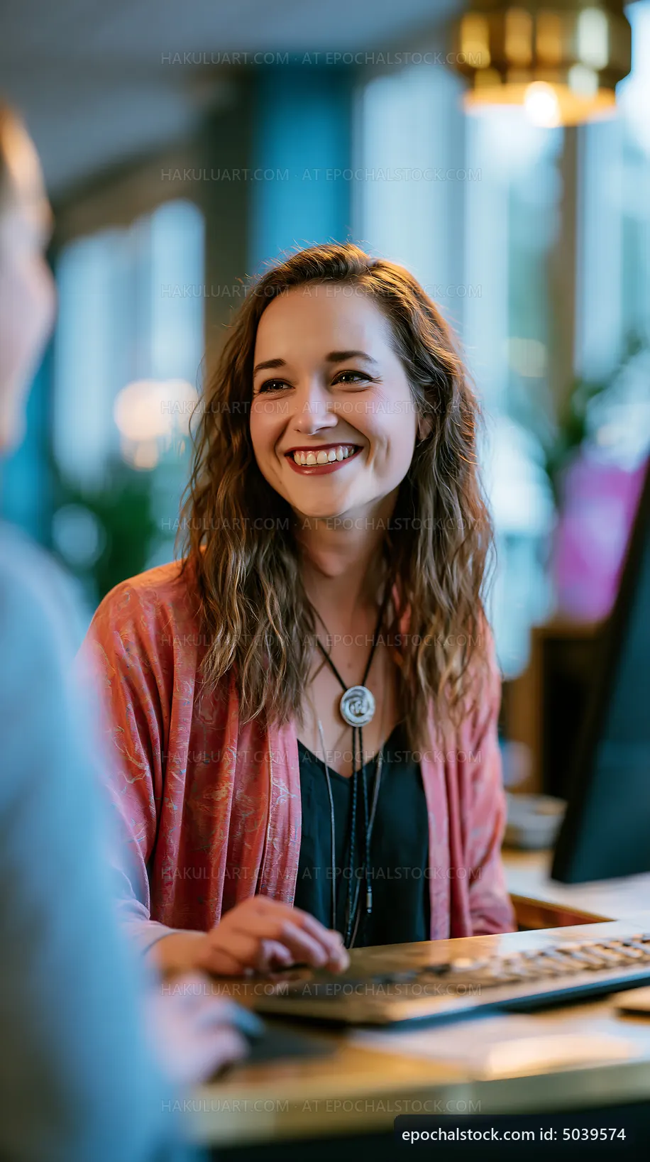 Woman smiles while working at a computer in a cafe