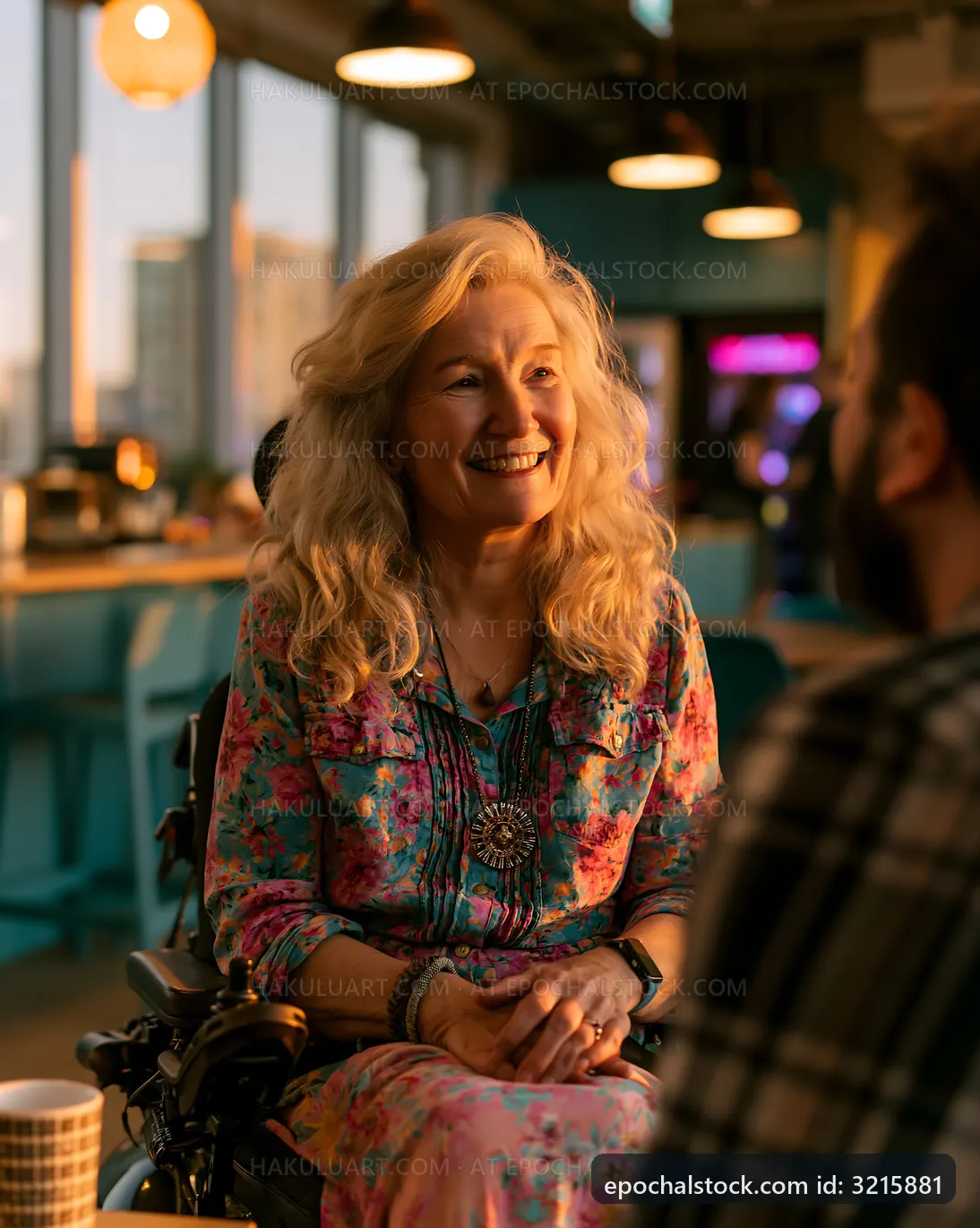 Woman in wheelchair smiling during conversation in modern cafe