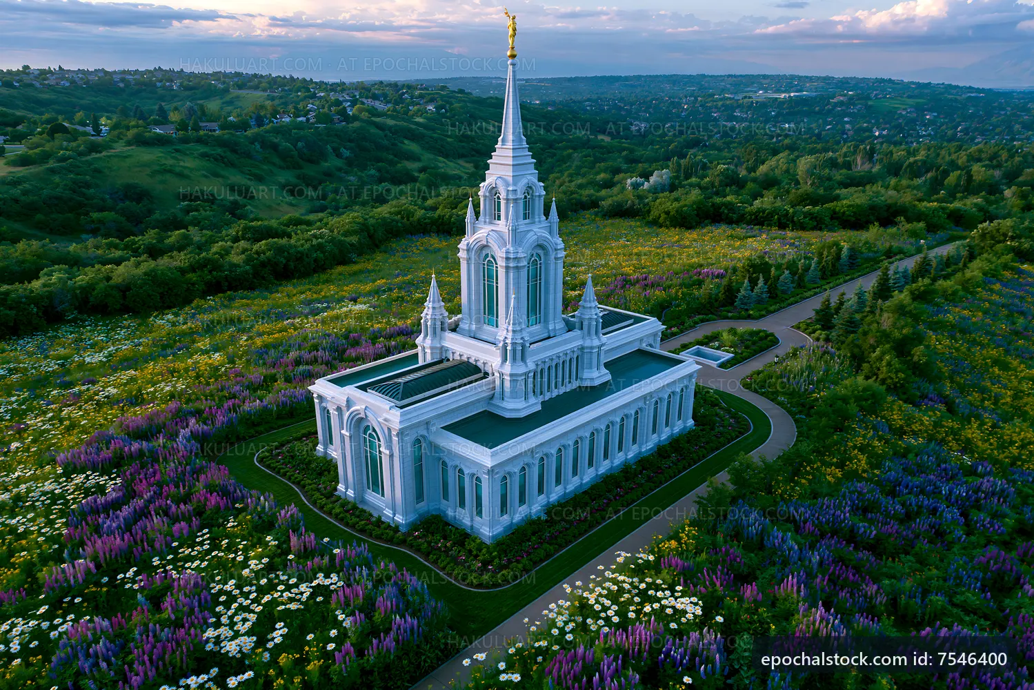 Flower fields surround a large white temple structure at sunset