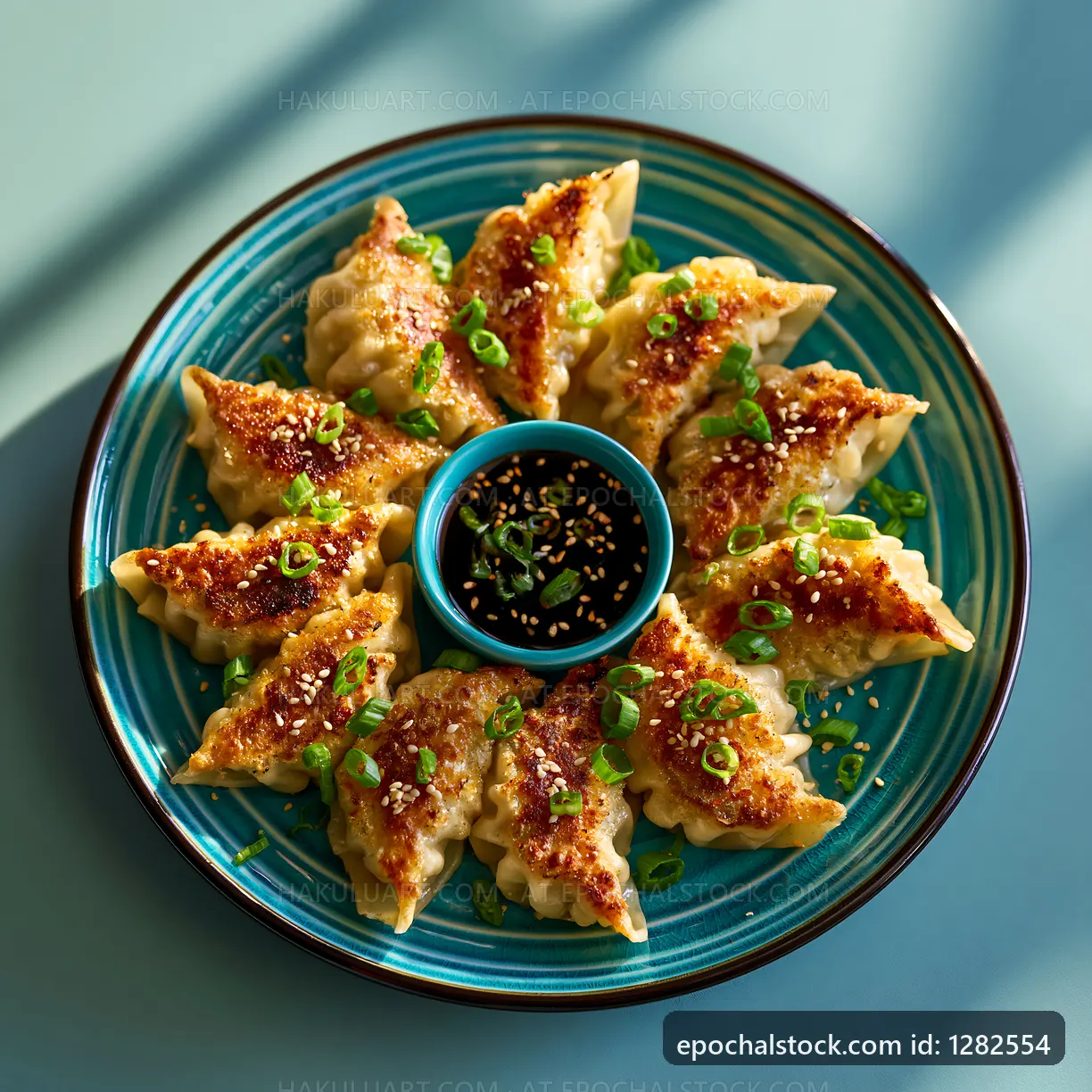 Dumplings served on a blue plate with sauce and green onions