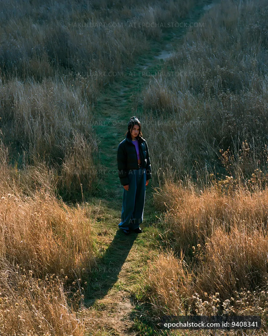 Person standing on a path in a field during daytime
