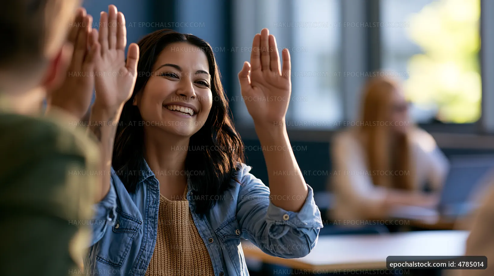 Group discussion in classroom with smiling woman raising hand