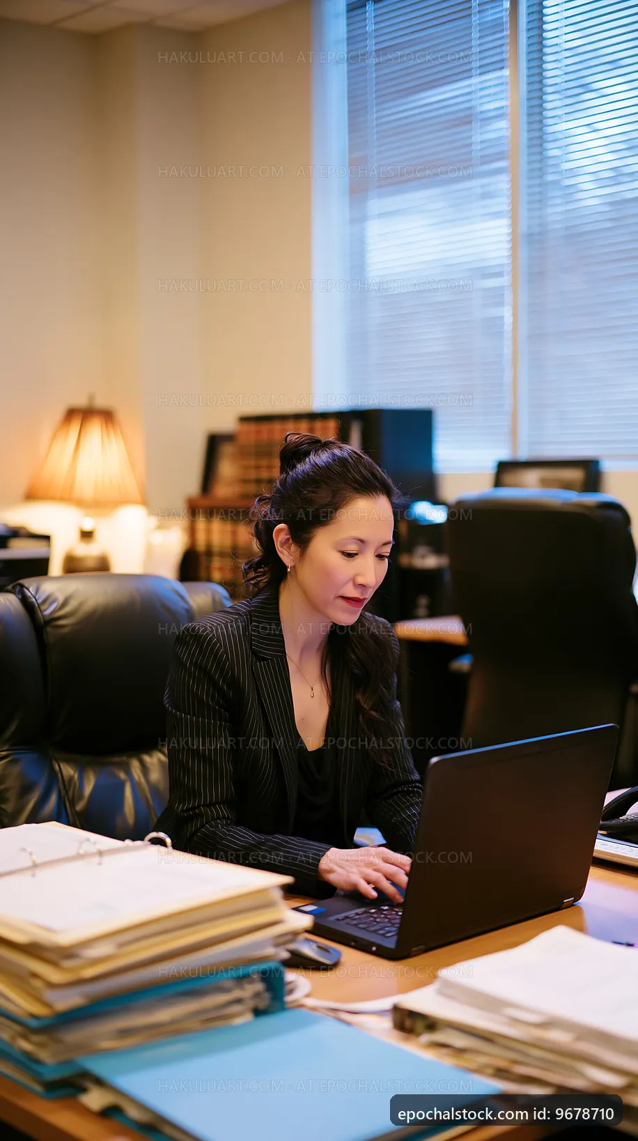 Woman working on laptop in office during day