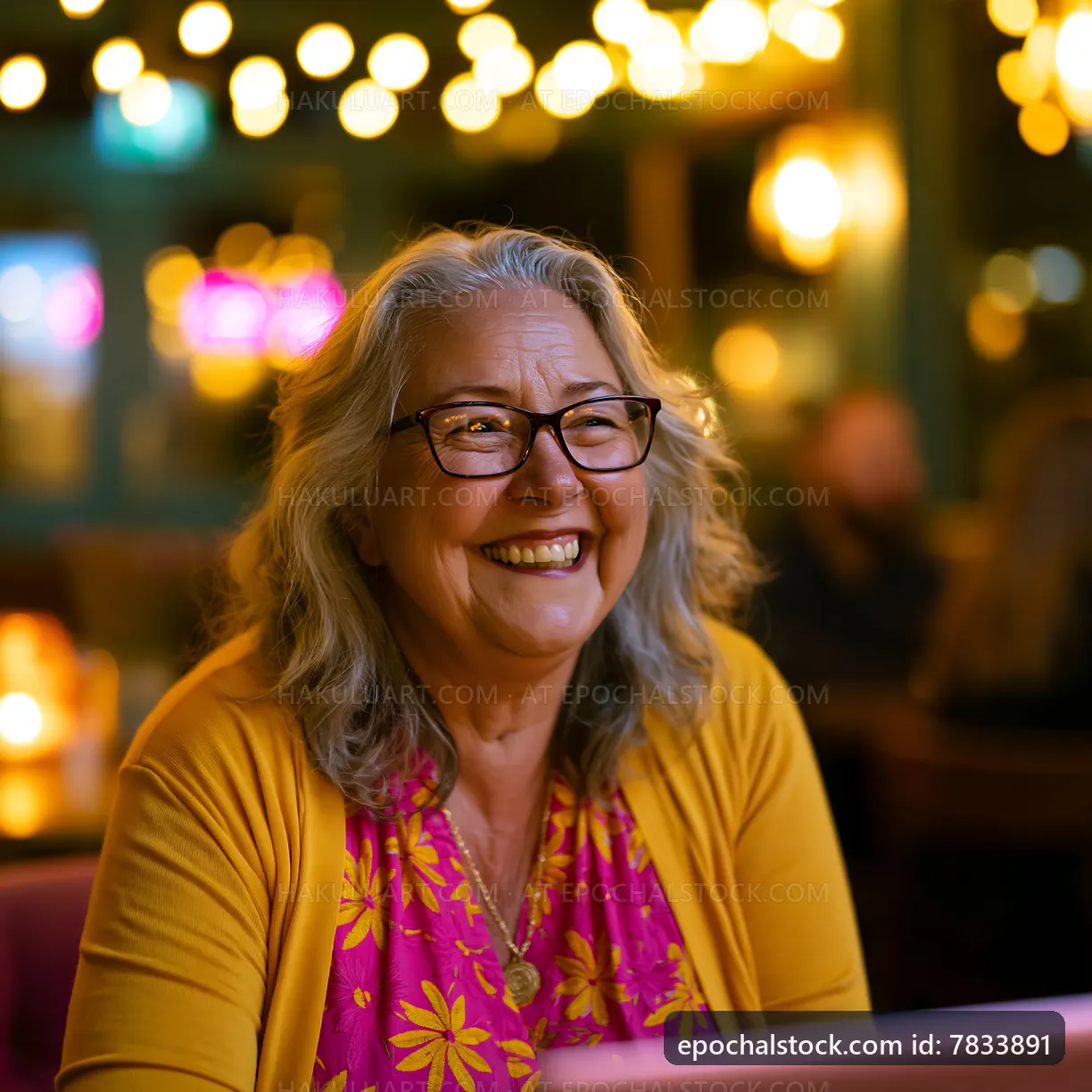 Smiling woman in a colorful top at a cozy cafe with soft lighting