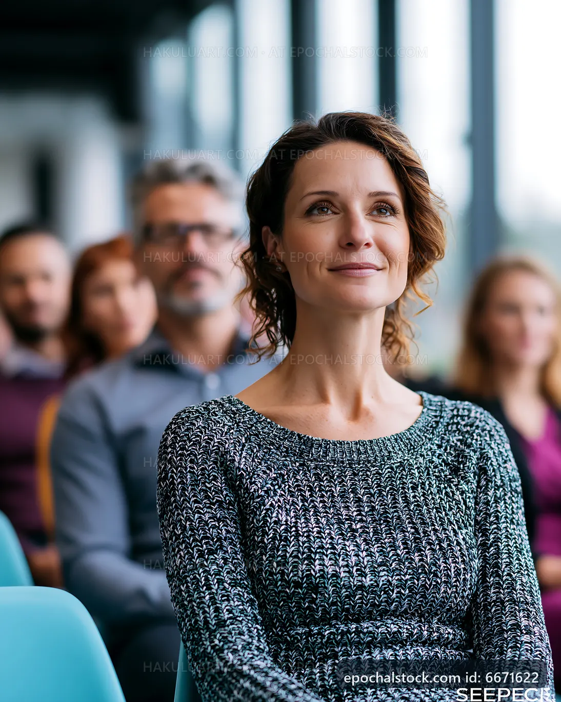 Woman smiles while listening to a speech in a conference room