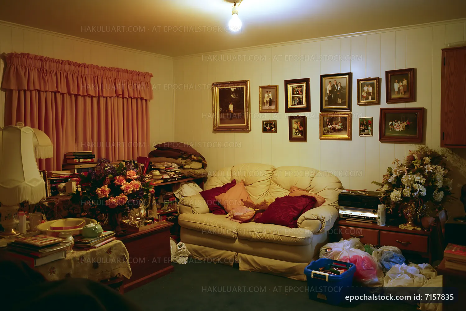 Living room with cluttered furniture and family photos on walls