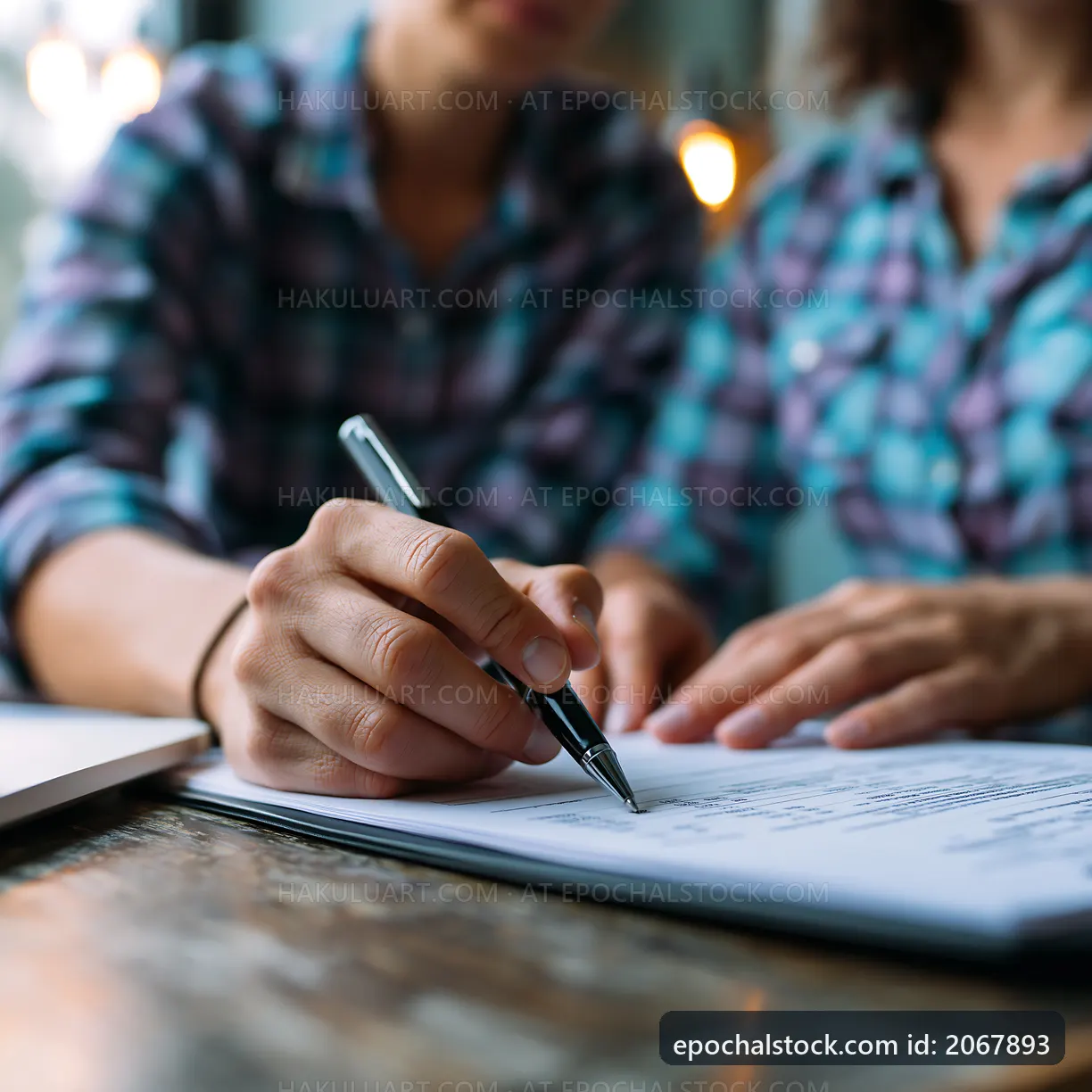 Two people working together on a contract signing at a table