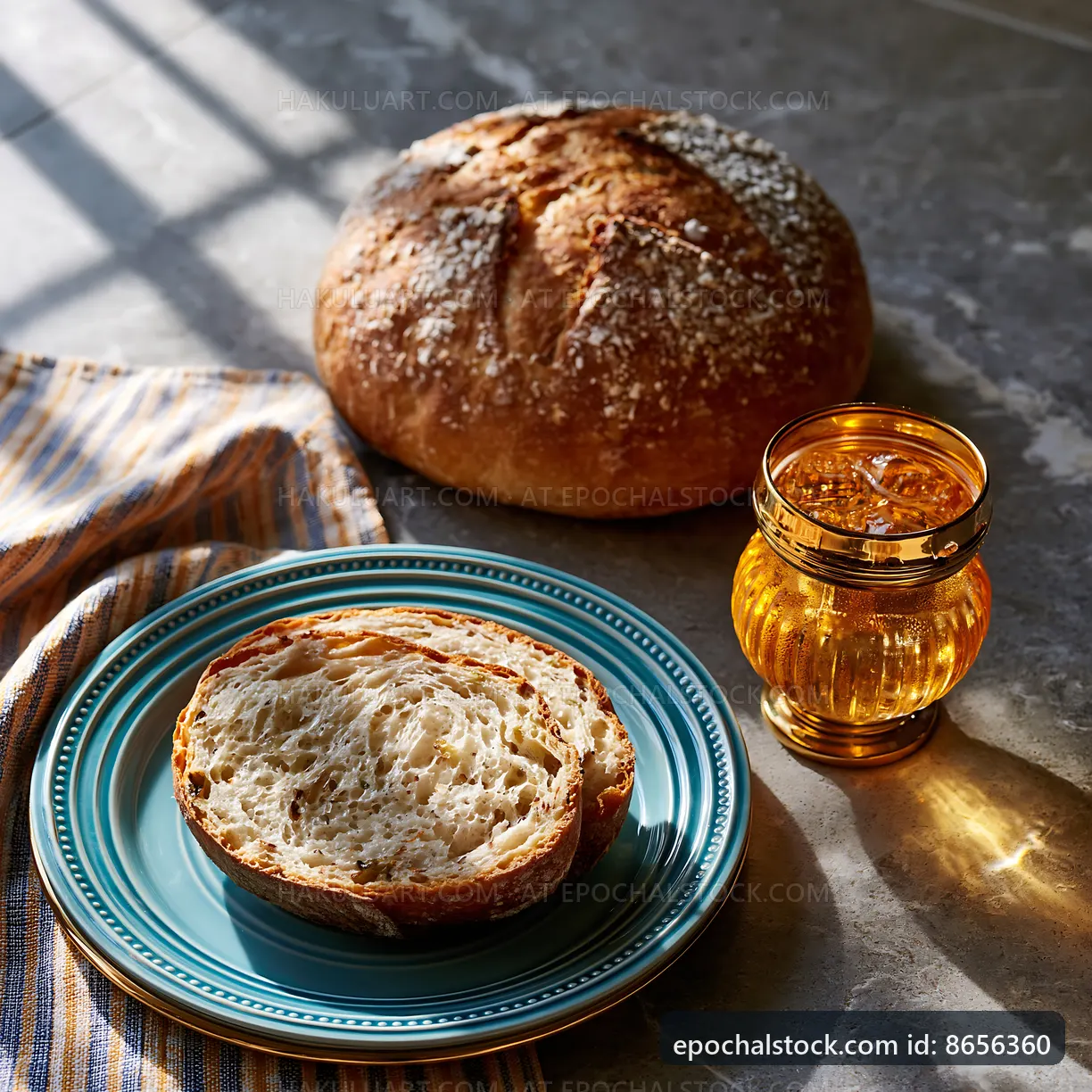 Fresh bread with slice on a plate beside glass of drink