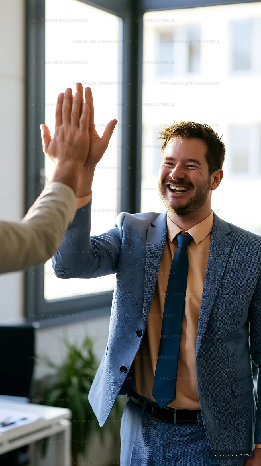 Business people high-fiving in modern office setting