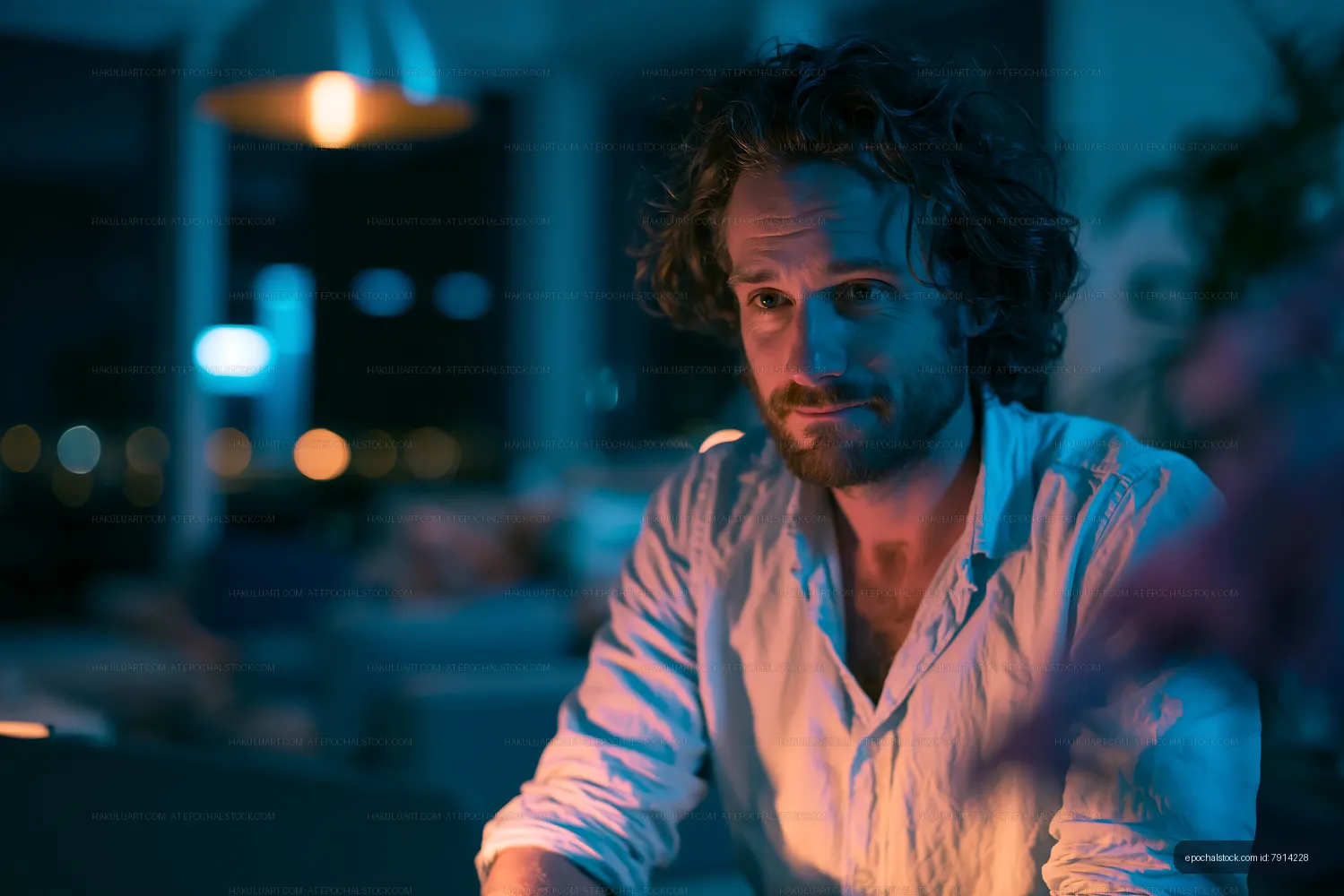 Man sitting in dimly lit room with blue lighting