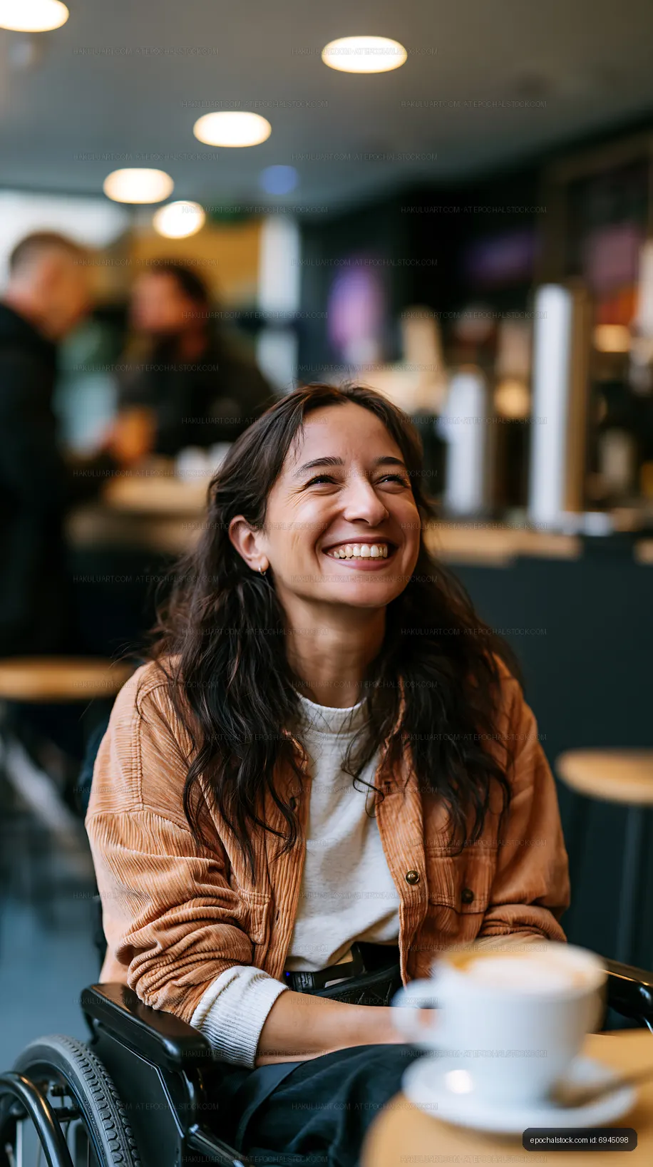 Woman in wheelchair smiling at cafe in modern setting