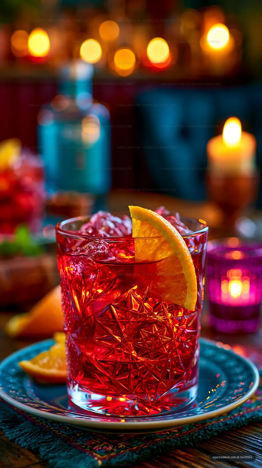 Bright red cocktail with orange slice in a dim setting