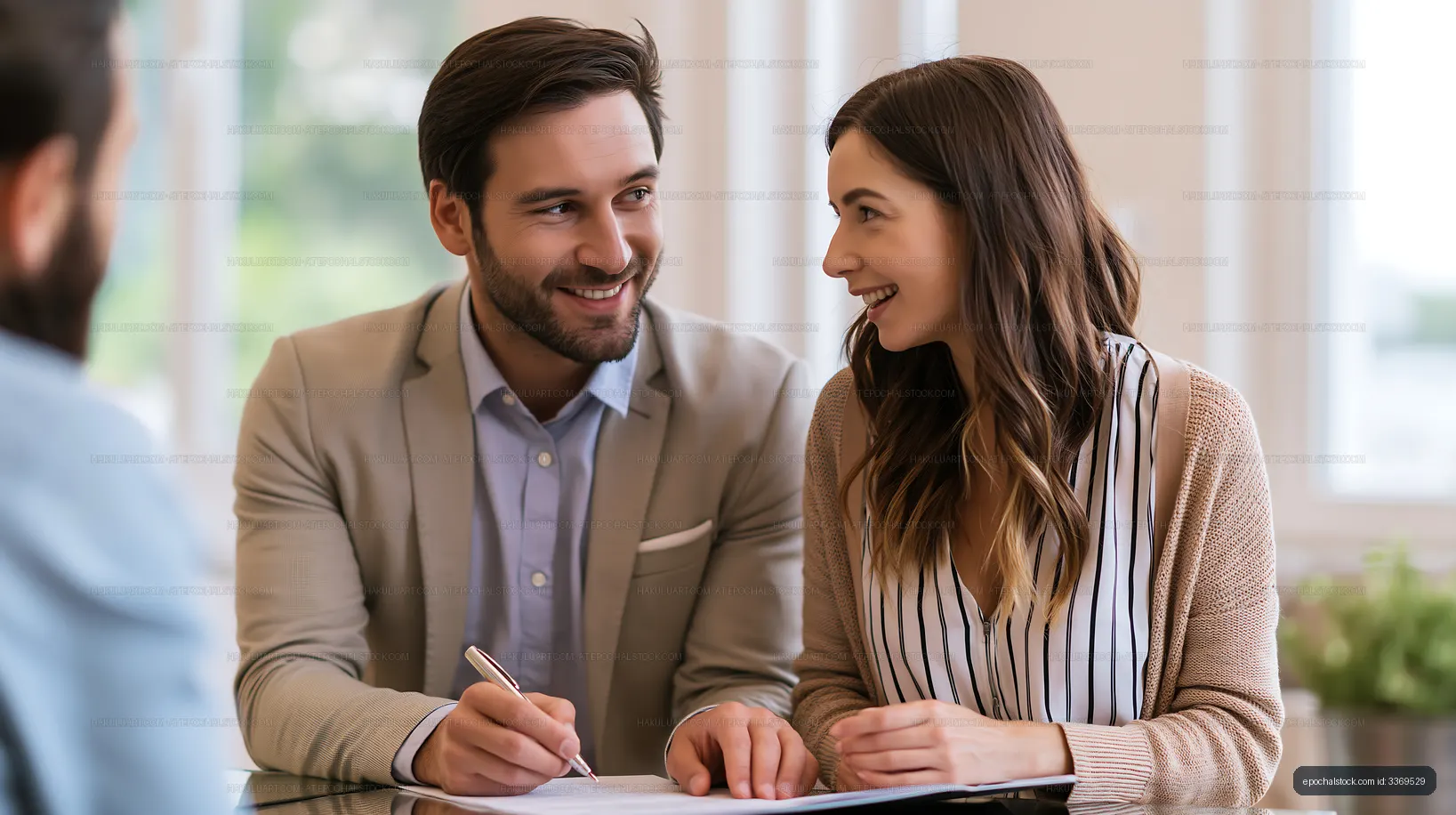 Couple discussing plans at a table in a bright office