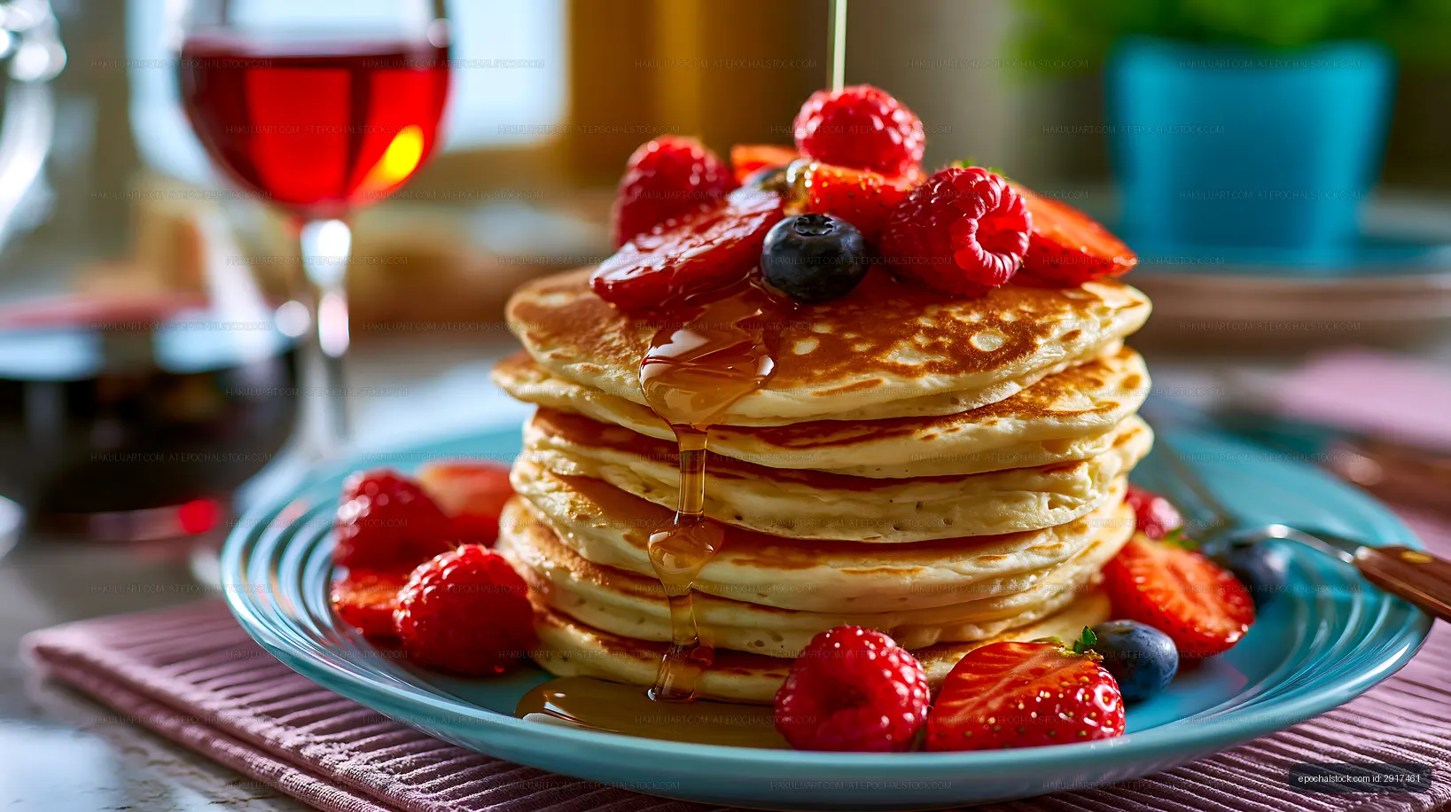 Stack of pancakes with berries and syrup on a blue plate